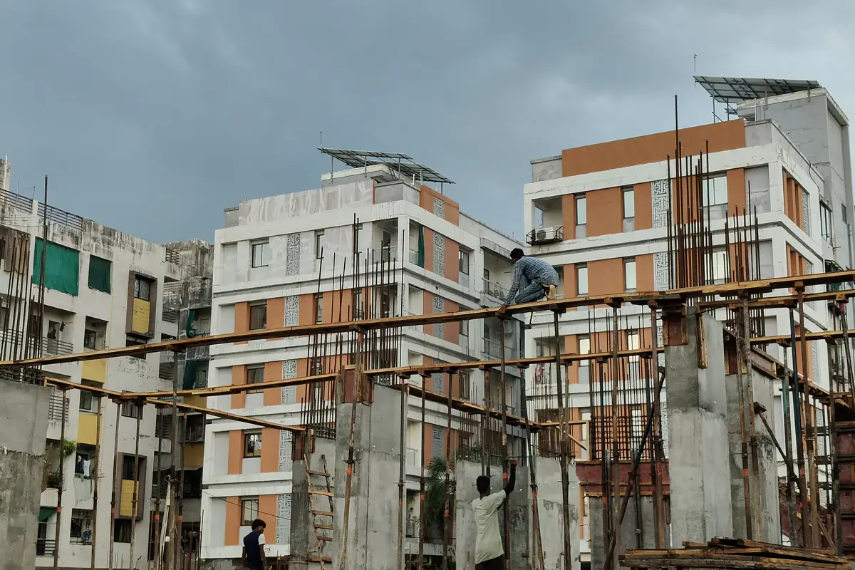 Ground-level columns rising with shuttering at Vasantara Skies, workers on site