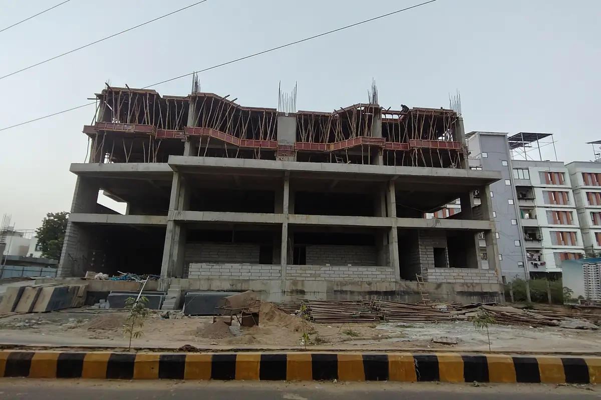 Vasantara Skies with ground, first and second floor slabs cast and next columns rising, seen from the road